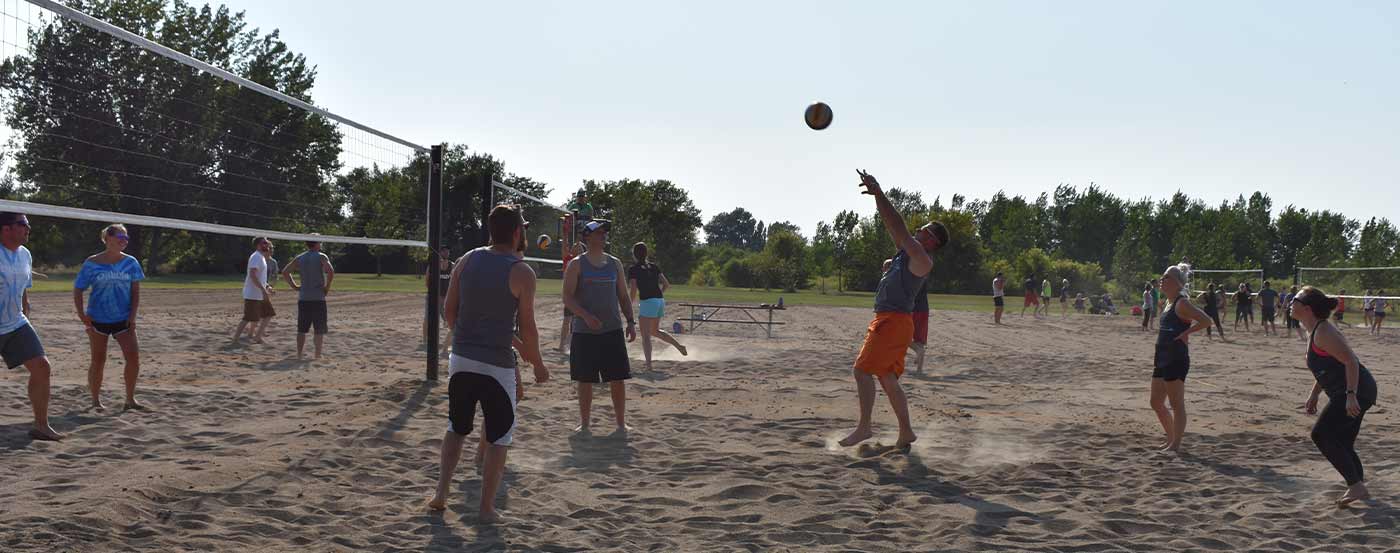 adults playing volleyball at a park